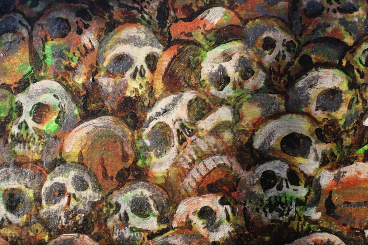Detail of skateboard deck, painted, depicting dozens of human skulls laying disorganized in a pile.
