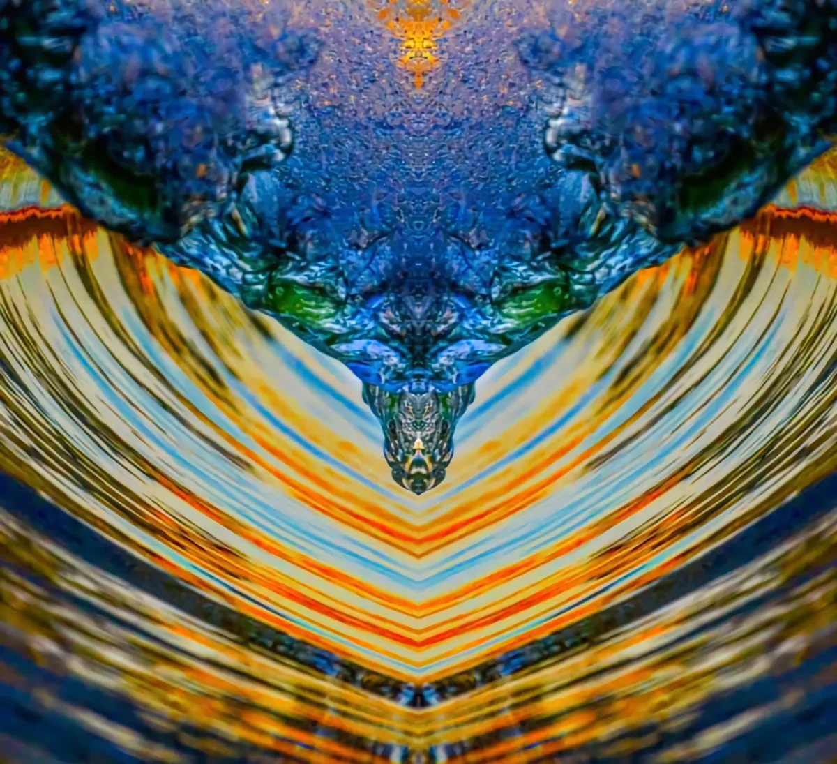 Digitally manipulated photo, abstracted. The square photo is horizontally mirrored. It is suggestive of blue water or glass in a funnel shape over multi-colored blue and oranged curved lines suggestive of a wave in the ocean.